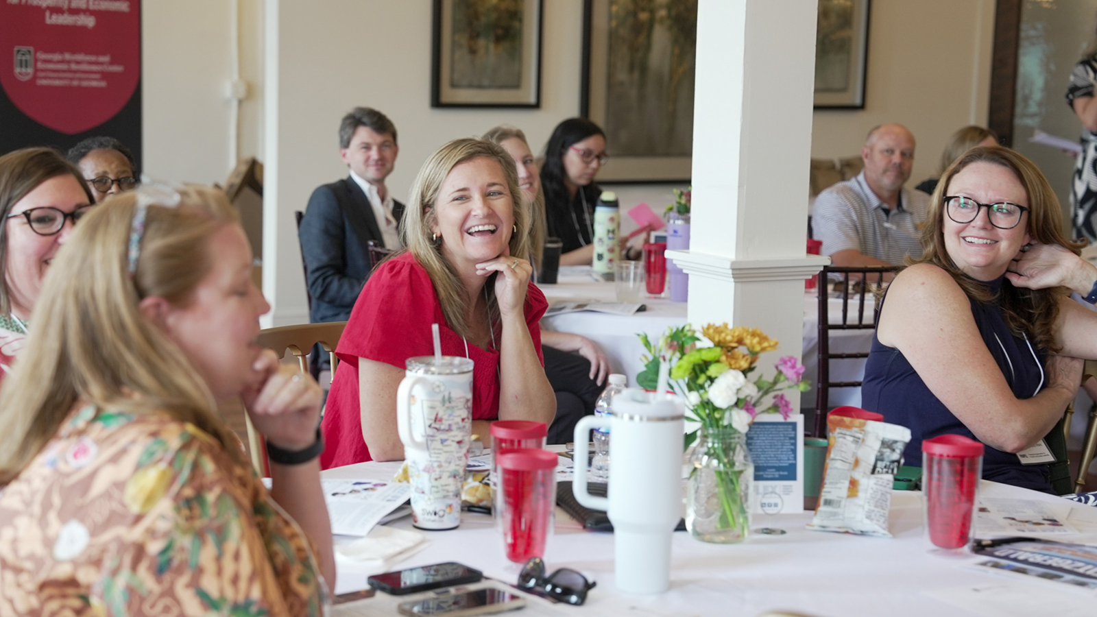 Women seated at a table share a laugh